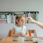 woman holding white plastic spoon